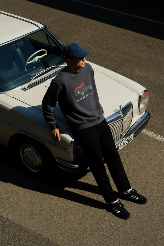Modelo con la sudadera SNOC Adventure junto al coche vintage