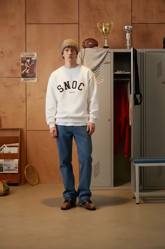 Modelo de pie en el vestuario con la sudadera blanca SNOC Since 1994