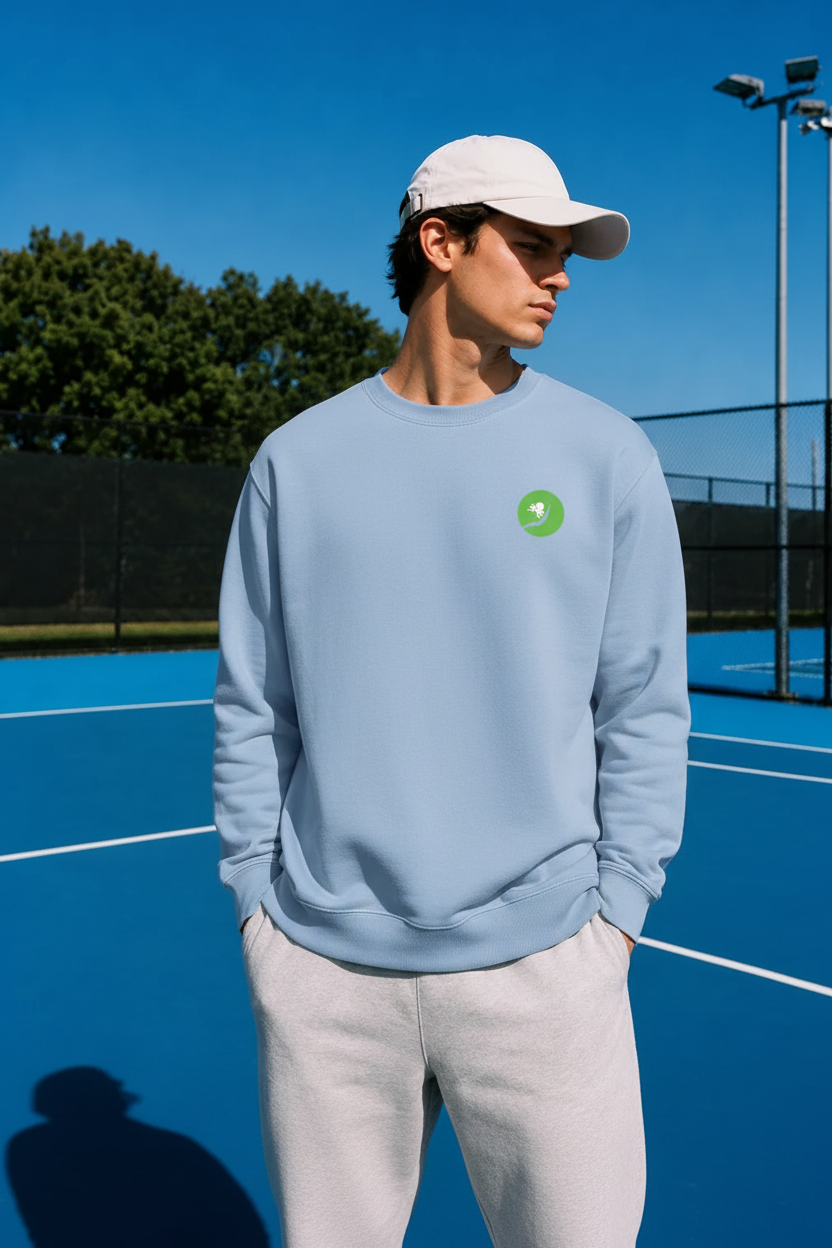 Modelo en la pista de tenis con la sudadera azul claro, vista delantera con logo verde