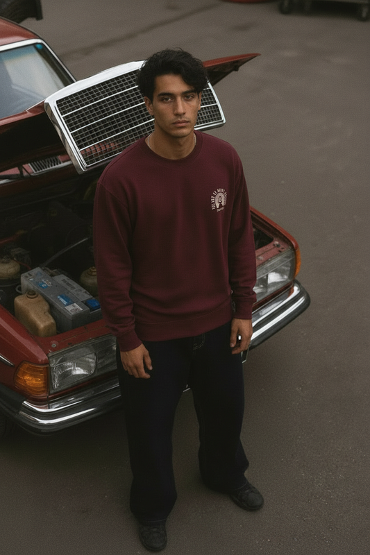 Modelo junto al coche rojo con la sudadera burdeos puesta