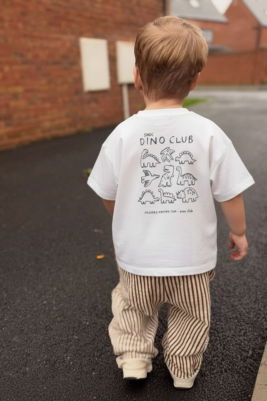 Niño caminando con la camiseta SNOC Dino Club