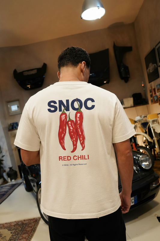 Camiseta Red Chili de SNOC vista por la espalda con las tres guindillas rojas estampadas, en un garaje