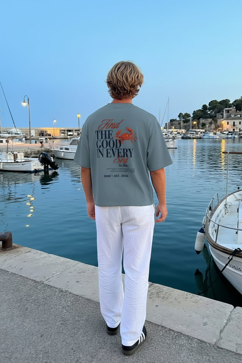 Camiseta SNOC Soul color Aguamarina, foto lifestyle en puerto mediterráneo, vista trasera con Find The Good
