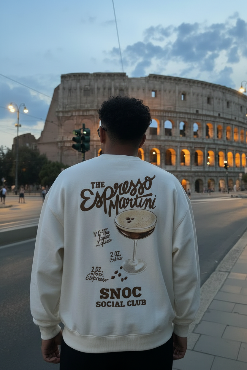 Sudadera Espresso Martini de SNOC vista por la espalda con la receta del cóctel y el sello SNOC Social Club, frente al Coliseo de Roma