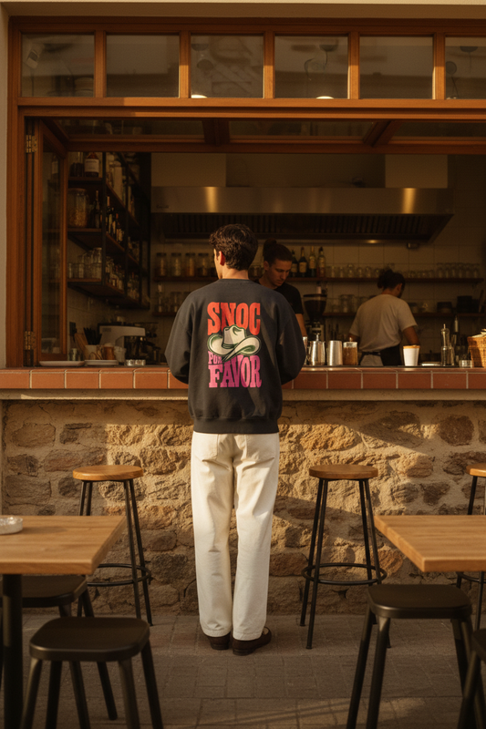 Sudadera SNOC Por Favor vista por la espalda con el sombrero vaquero y el lettering completo, en un café